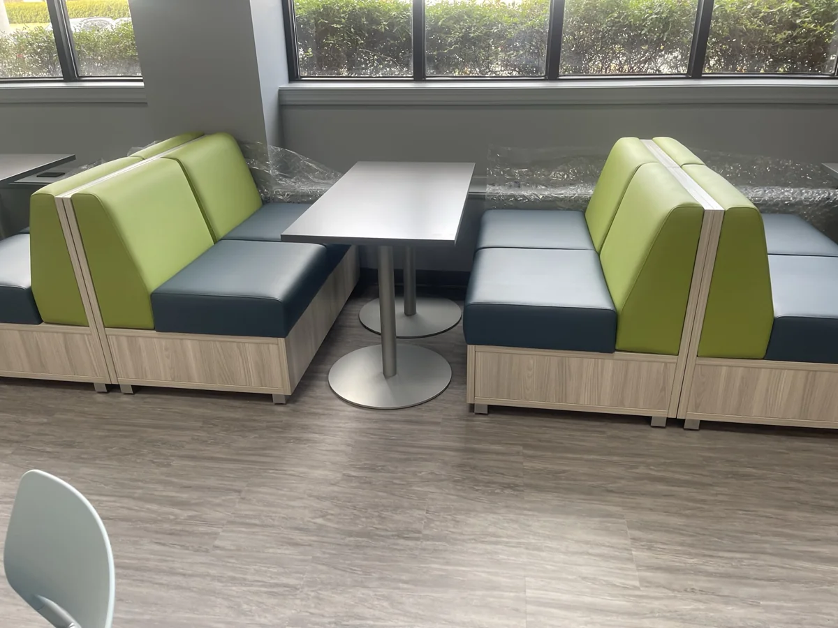 Green and charcoal booth seating around café tables by windows